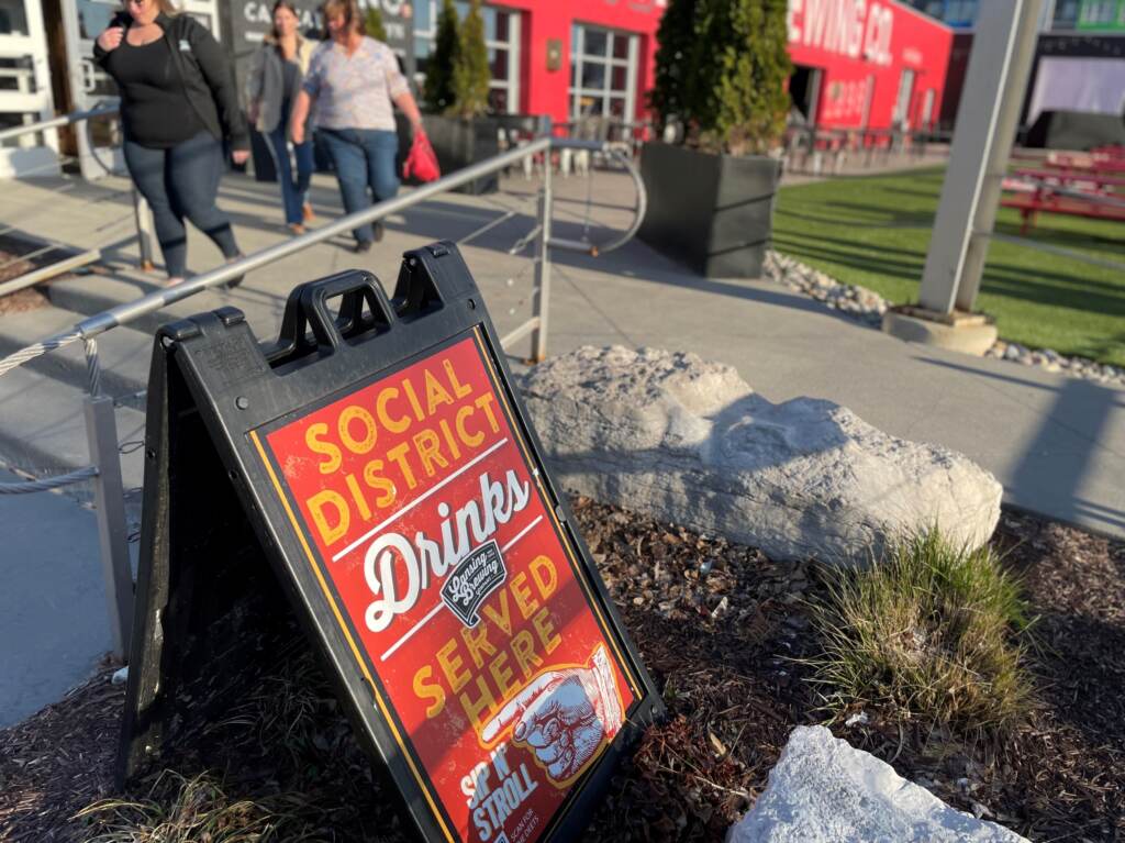 A sign outside the Lansing Brewing Company in Lansing, Michigan advertises a social district where people can buy alcohol-to-go and drink it within the boundaries of an outdoor downtown zone. A sign outside the Lansing Brewing Company in Lansing, Michigan advertises a social district where people can buy alcohol-to-go and drink it within the boundaries of an outdoor downtown zone. (Sarah Lehr)