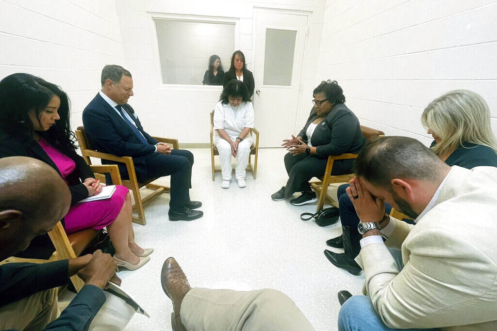 Texas Execution In this April 6, 2022 photo provided by Texas state Rep. Jeff Leach, Texas death row inmate Melissa Lucio, dressed in white, leads a group of seven Texas lawmakers in prayer in a room at the Mountain View Unit in Gatesville, Texas.