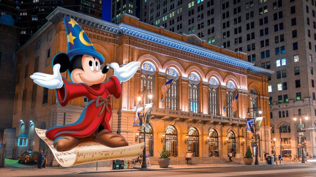 An image of Mickey Mouse in the foreground with the Academy of Music on South Broad Street in the background.