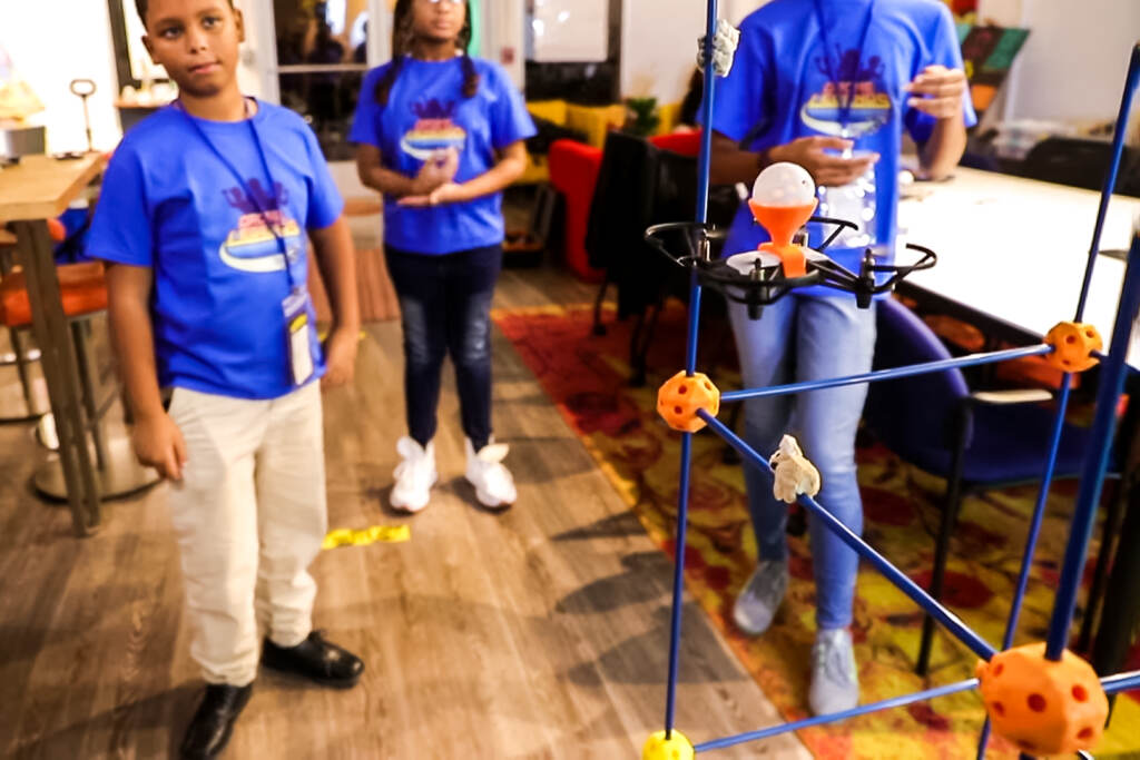 m&m-4×6-Drones-in-the-classroom_-The-future-of-STEM-Education—Movers-&-Makers-(2022)-5-50-screenshot Three students flying a drone in a classroom