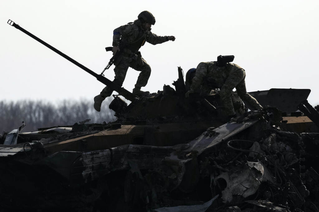 Russia Ukraine War A Ukrainian serviceman walks on a destroyed Russian fighting vehicle in Bucha