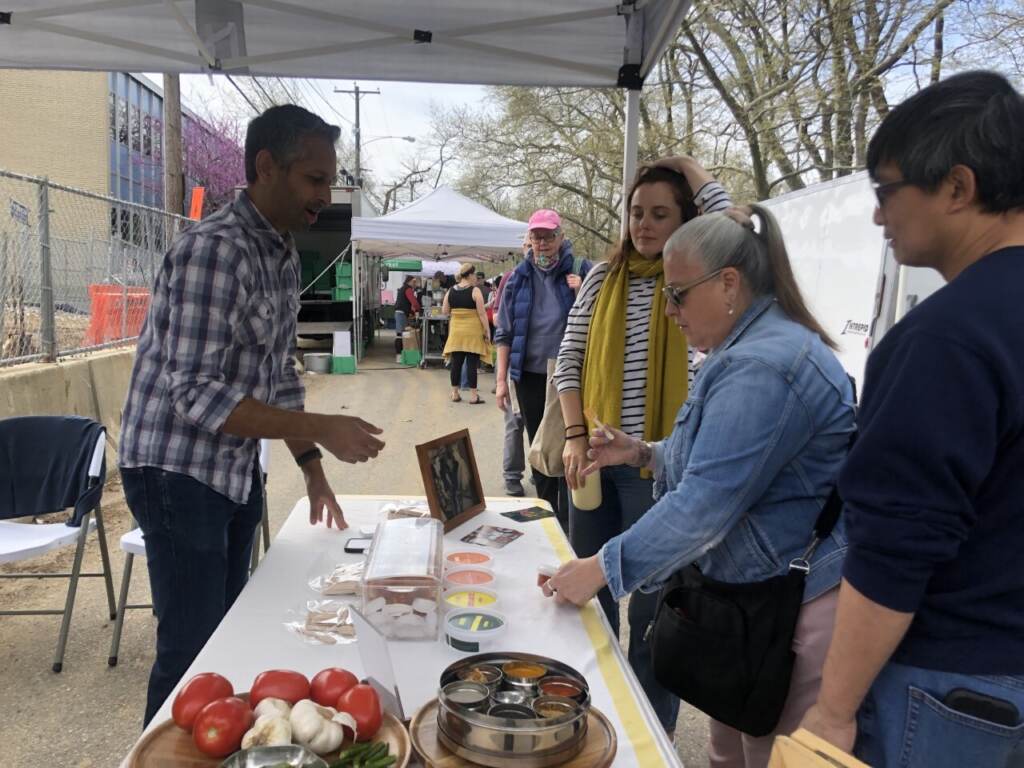 Clark Park farmer's market customers sample indian coastal cuisine made by Aaji’s. (Emily Rizzo/WHYY News)