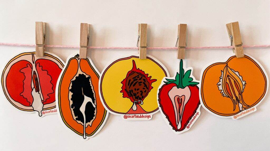 Art featuring fruit hangs on a white wall.