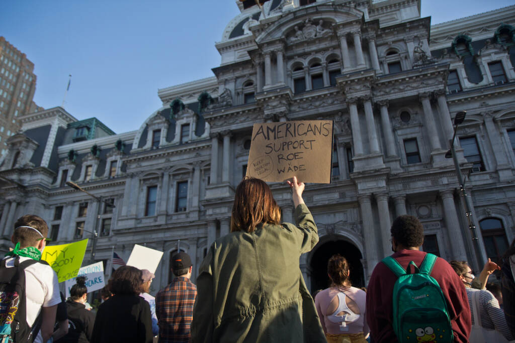 2022 05 03 k paynter abortion rights rally-7 A person stands in a crowd of people in front of City Hall, holding a sign that says,