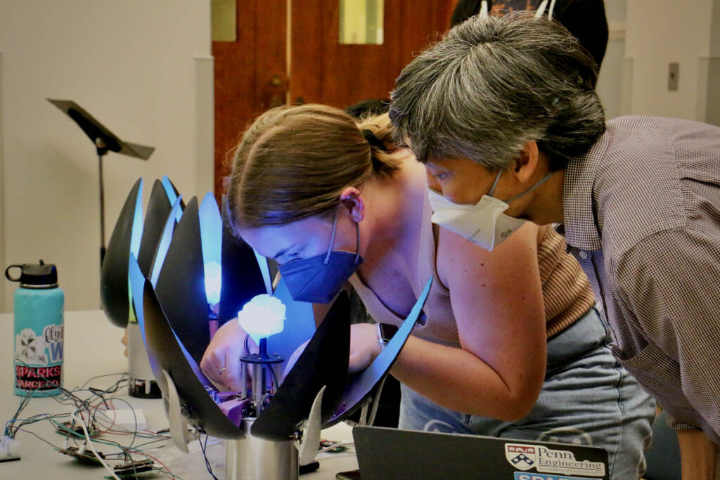 2022 05 12-e lee-lilian stoesser-philadelphia settlement school-beyond the binary choral Penn GRASP Lab student Lilian Stoesser works on a robotic flower that is programmed to open and close in response to the music of ''Beyond the Binary.''