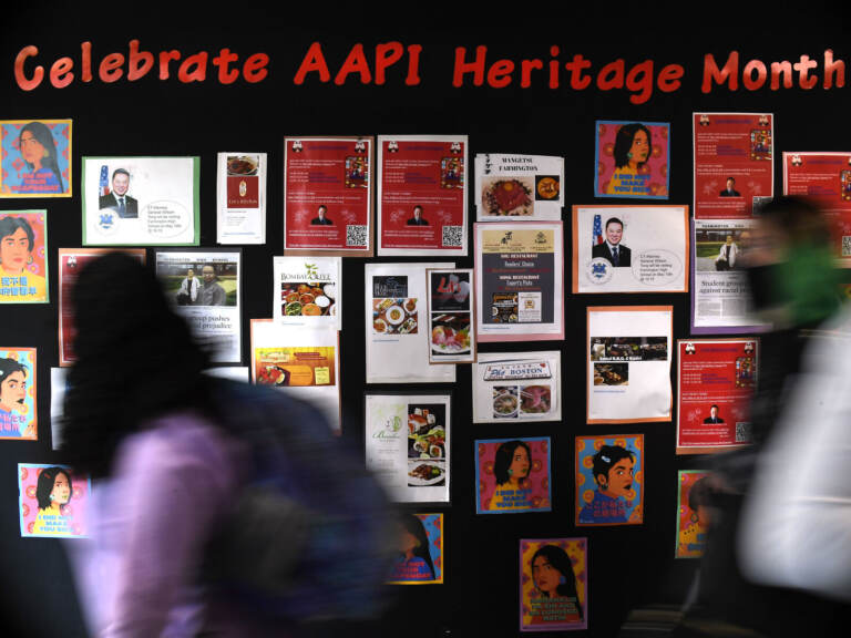 Students walk past a display for Asian Pacific American Heritage Month