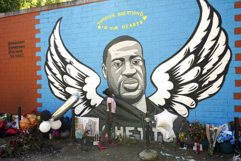 Nala Williams, 8, looks up at a mural honoring George Floyd in the Third Ward, Sunday, June 7, 2020, in Houston. (AP Photo/David J. Phillip