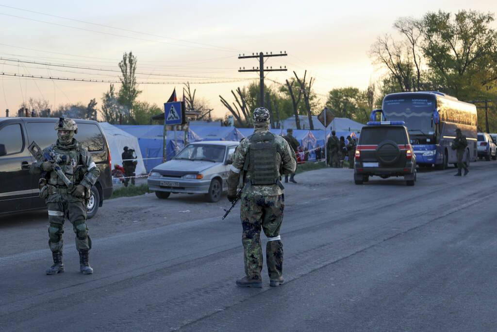 Ukraine Russia Servicemen of Russian Army and Donetsk People's Republic militia guard the camp where local residents who left a shelter in the Metallurgical Combine Azovstal temporary staying in Bezimenne, in territory under the government of the Donetsk People's Republic, eastern Ukraine, Friday, May 6, 2022. (AP Photo/Alexei Alexandrov)