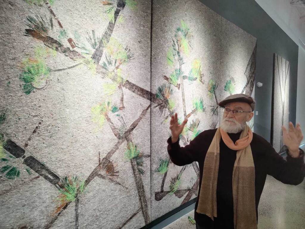 antonio-martorell-taller-puertorriqueno-exhibition Puerto Rican artist Antonio Martorell stands in front of an artwork depicting a tree.