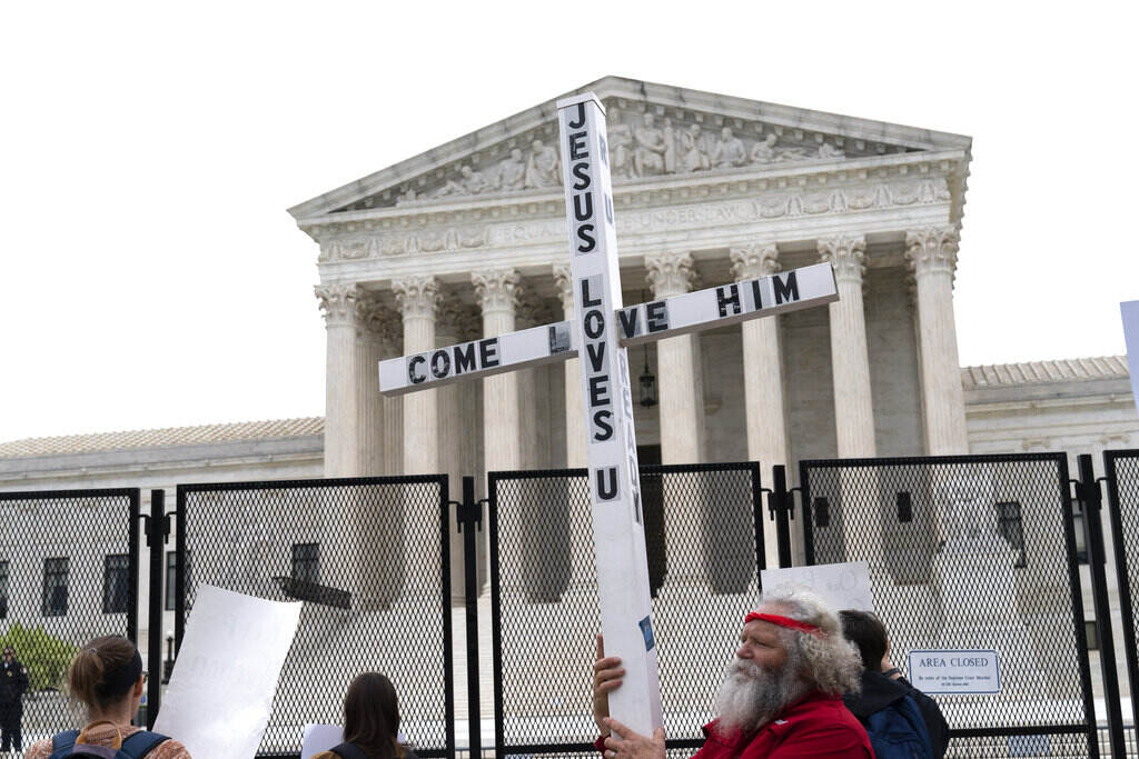 Supreme Court File photo: A demonstrator holding a cross protests outside of the U.S. Supreme Court, Thursday, May 5, 2022, in Washington.