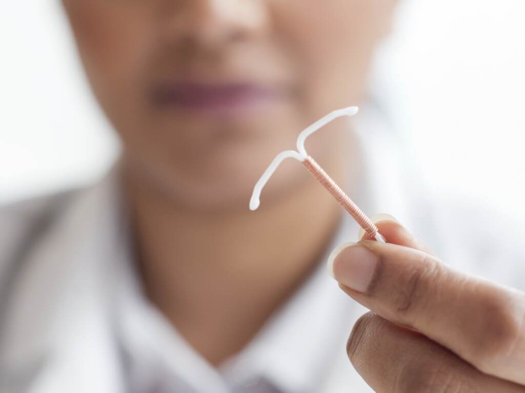 Copper IUDs are a highly effective method of contraception. Some abortion rights opponents express moral objections to IUDs and other birth control methods. A doctor holds up an IUD