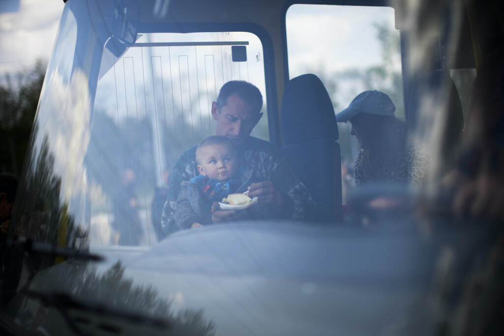 Russia Ukraine War A man feeds a baby on a bus full of evacuees in Ukraine