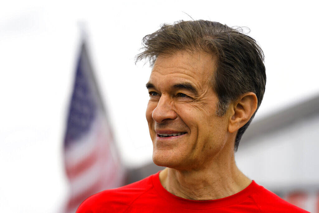 Election 2022 Senate Pennsylvania Close-up of Mehmet Oz, who is smiling, with an American flag in the background.
