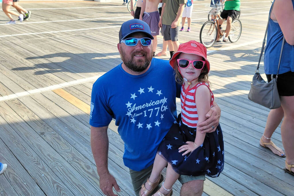 ocean-city-jersey-shore-t-macdonald-2022-05-30-4 Bruce Vincent and his daughter Zoey watching the flag raising ceremony on the Ocean City N.J. boardwalk. (Tom MacDonald/WHYY)