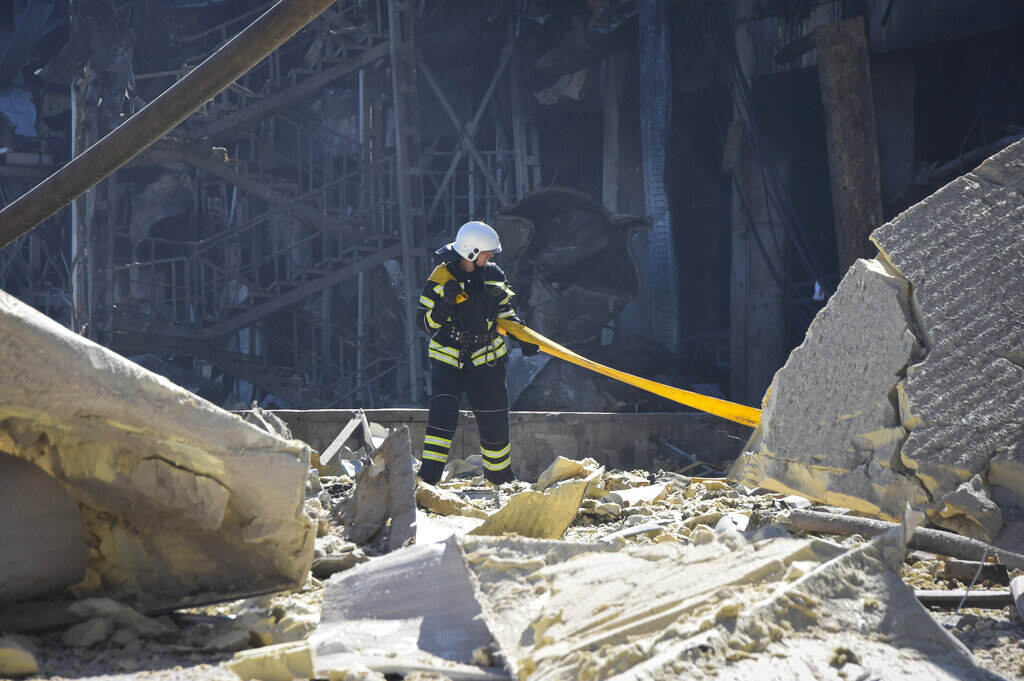 Russia Ukraine War A firefighter walks amid destroyed buildings in Ukraine.