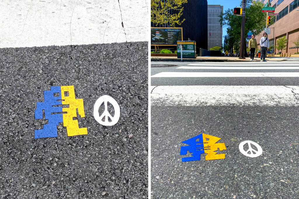 stikman-streetart-copy A blue and yellow figure is visible on a crosswalk in two photos side-by-side.