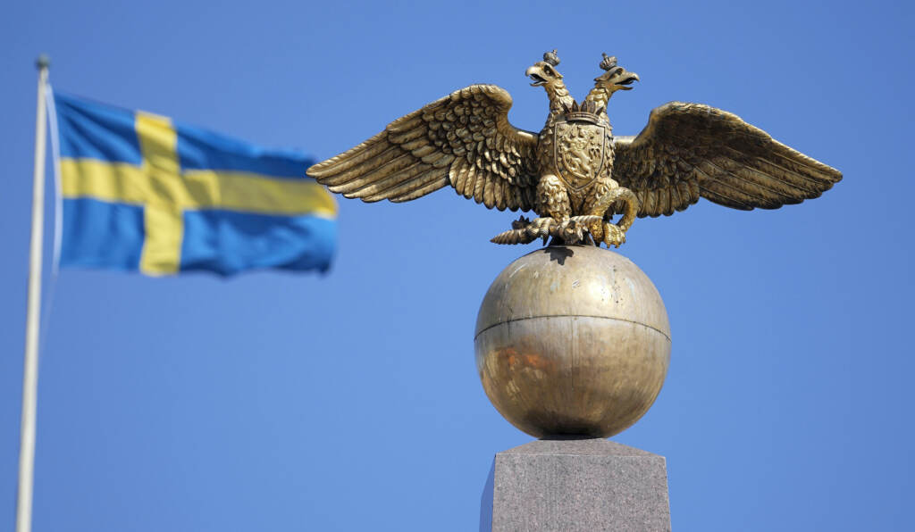 Russia Ukraine War NATO Explainer A Russian Imperial double-headed eagle is seen in front of a Sweden flag on the Czarina's Stone in the Market Square, in Helsinki, Finland, Friday, May 13, 2022. Finnish leaders announced Thursday their belief that Finland should join the world's biggest military organization because of Russia's war in Ukraine. Sweden could soon follow suit. (AP Photo/Martin Meissner)