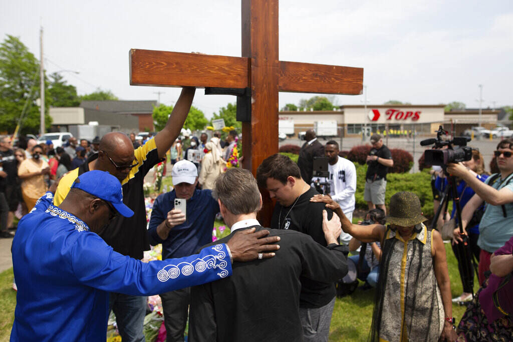 Buffalo Supermarket Shooting A group of mourners gather in front of a cross.