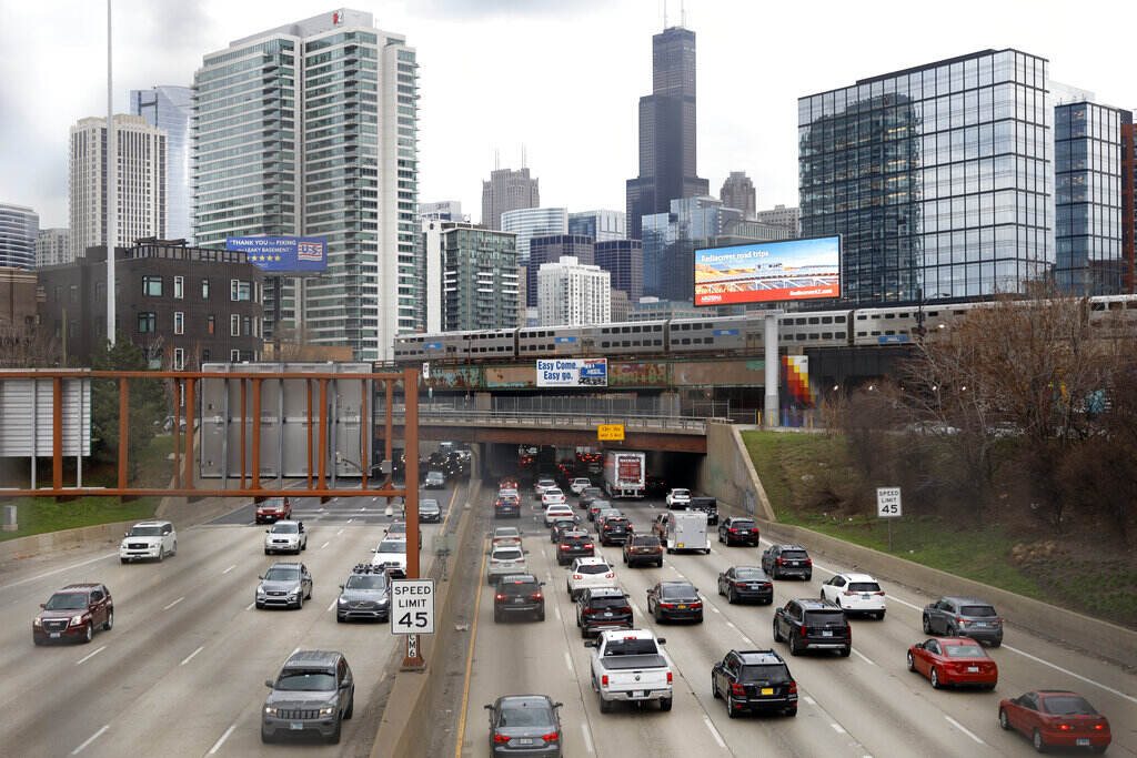 Buttigieg Roadway Fatalities File photo: Traffic flows along Interstate 90 highway as a Metra suburban commuter train moves along an elevated track in Chicago on March 31, 2021. With upcoming data showing traffic deaths soaring, the Biden administration is steering $5 billion in federal aid to cities and localities to address the growing crisis by slowing down cars, carving out bike paths and wider sidewalks, and nudging commuters to public transit.