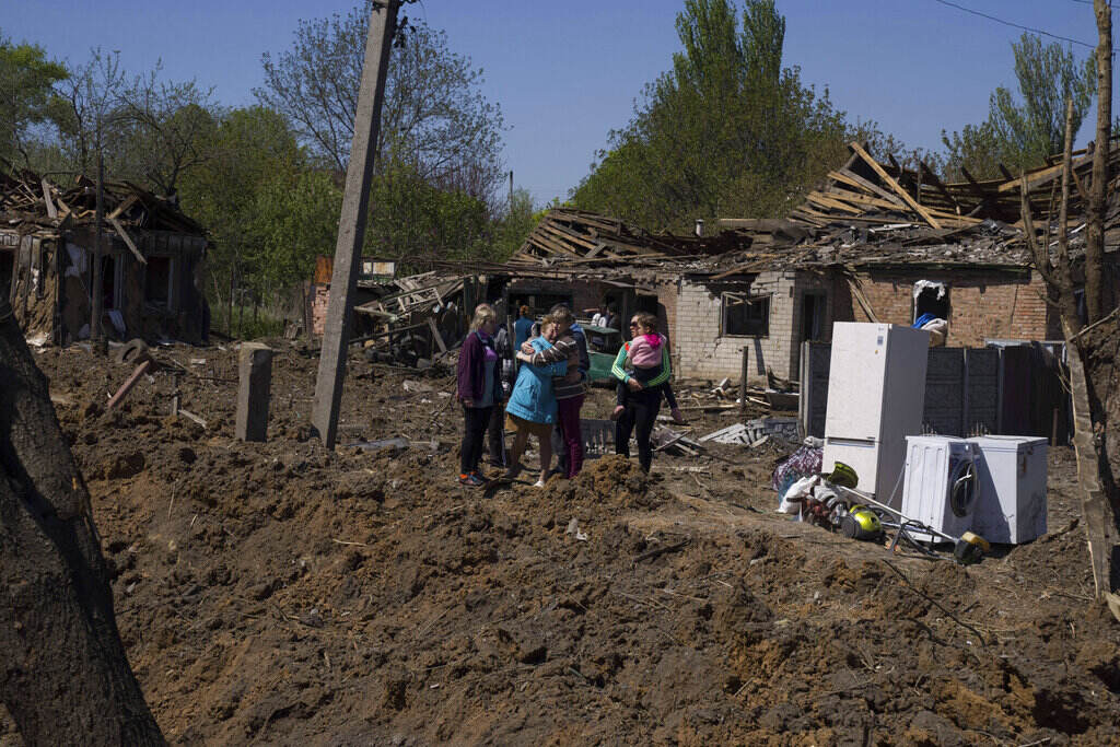 APTOPIX Russia Ukraine War People react as they stand next to a crater in destroyed residential area after Russian airstrike in Bakhmut, Donetsk region, Ukraine, Saturday, May 7, 2022.