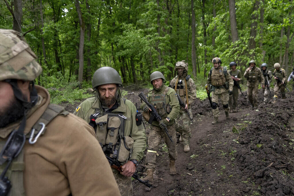 Russia Ukraine War Ukrainian servicemen walk in the forest near a recently retaken village, north of Kharkiv, east Ukraine, Sunday, May 15, 2022.