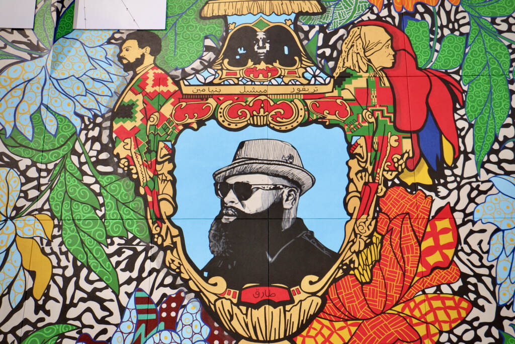 Black Thought is the central figure in a 4-story mural on the south side of the new Clay Studio building in Kensington. Profiles of Black poets Sonia Sanchez and Amiri Baraka are worked into the handles of the vase.(Emma Lee/WHYY)