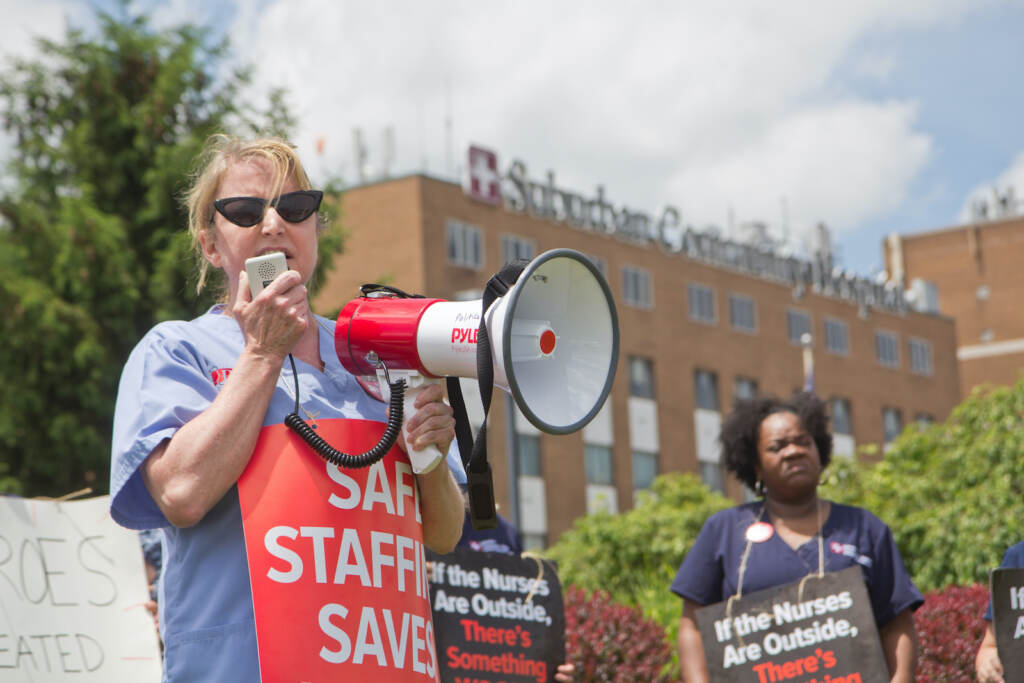 2022 06 08 k paynter suburban community maureen may pasnap (1 of 1) Maureen May holds a protest sign and speaker at a protest outside Suburban Community Hospital