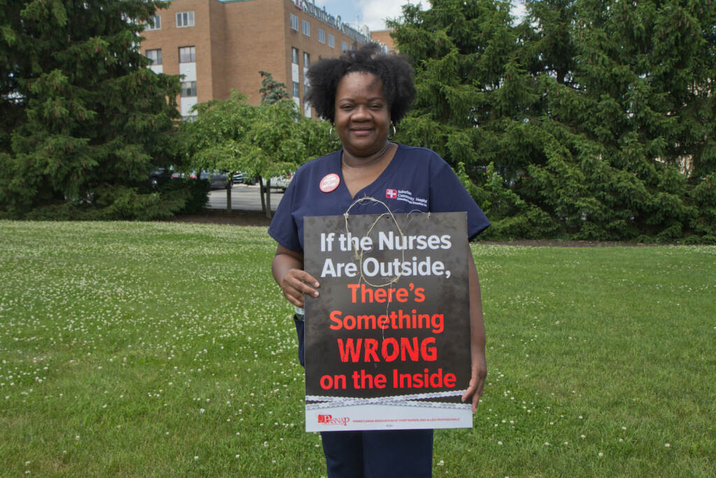 Terena Stinson holds a protest sign outside Suburban Community Hospital