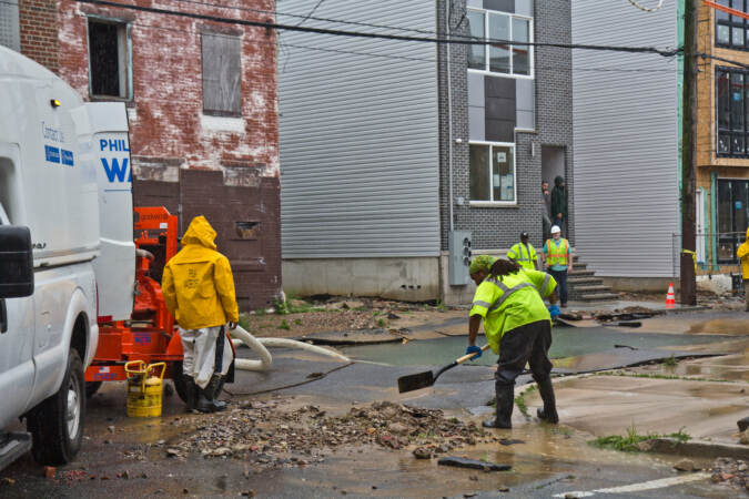 Crews are pictured at the scene of a water main break at 4th and Hewson streets