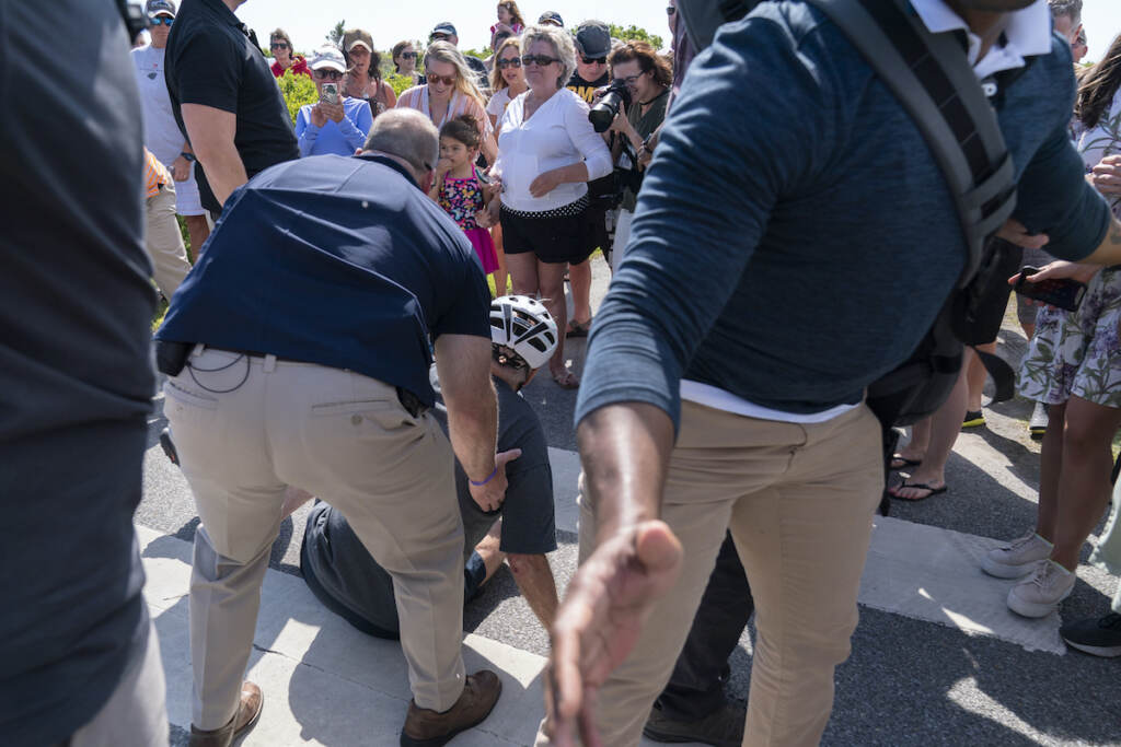 Joe Biden President Joe Biden is helped by U.S. Secret Service agents after he fell trying to get off his bike to greet a crowd on a trail at Gordons Pond in Rehoboth Beach, Del., Saturday, June 18, 2022. (AP Photo/Manuel Balce Ceneta)