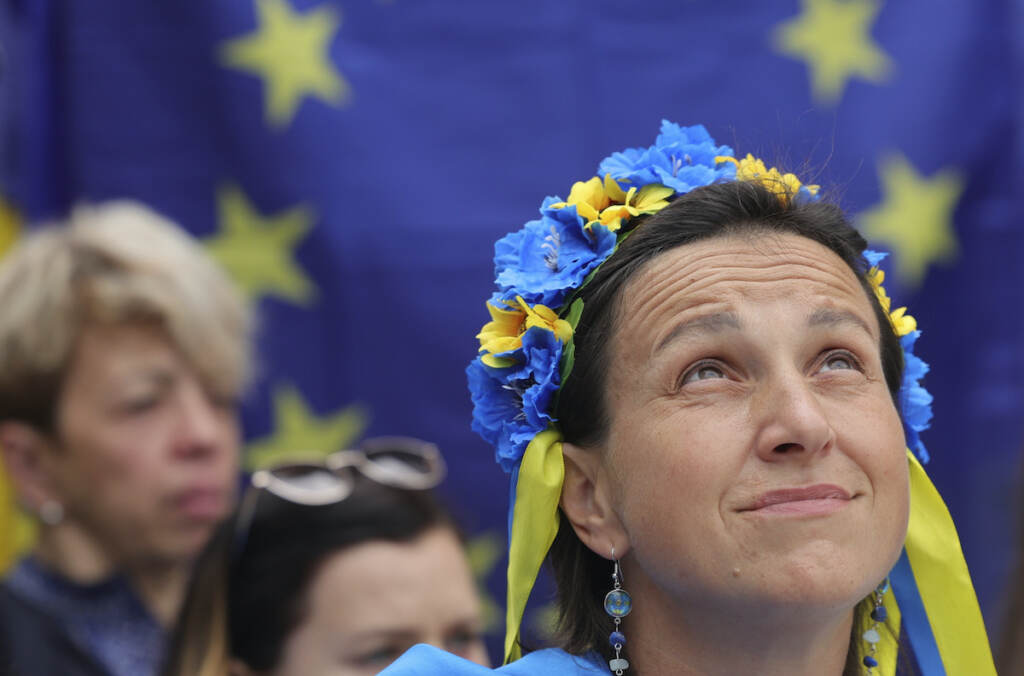 Belgium EU Summit A protestor wears a flower headband in the Ukraine colors as she participates in a demonstration in support of Ukraine outside of an EU summit in Brussels, Thursday, June 23, 2022. (AP Photo/Olivier Matthys)