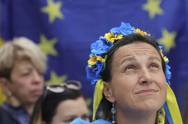 A protestor wears a flower headband in the Ukraine colors as she participates in a demonstration in support of Ukraine outside of an EU summit in Brussels, Thursday, June 23, 2022. (AP Photo/Olivier Matthys)
