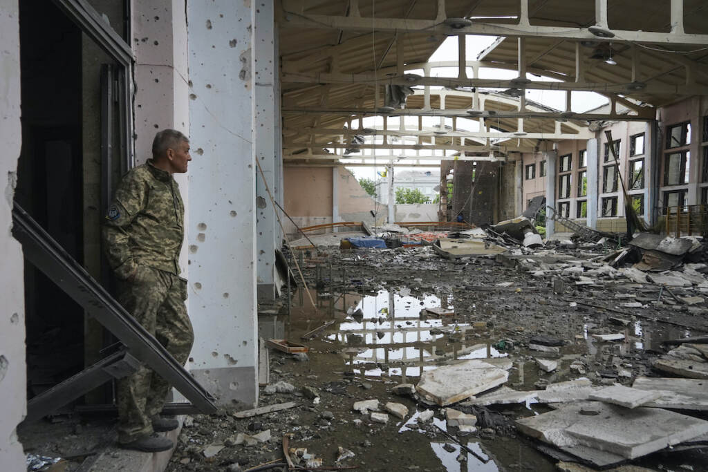 APTOPIX Russia Ukraine War A Ukrainian serviceman looks at the ruins of the sports complex of the National Technical University in Kharkiv, Ukraine, Friday, June 24, 2022, damaged during a night shelling. The building received significant damage. A fire broke out in one part but firefighters managed to put it out. (AP Photo/Andrii Marienko)