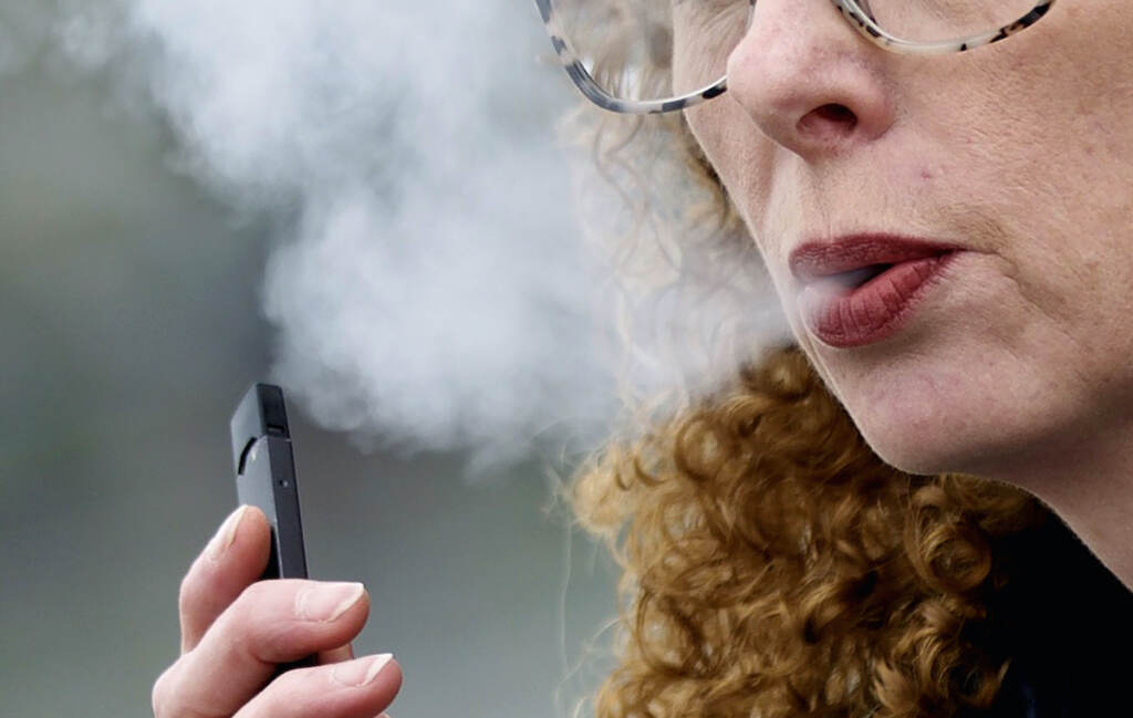 File photo: A woman exhales while vaping from a Juul pen e-cigarette in Vancouver, Wash., April 16, 2019. (AP Photo/Craig Mitchelldyer, File)