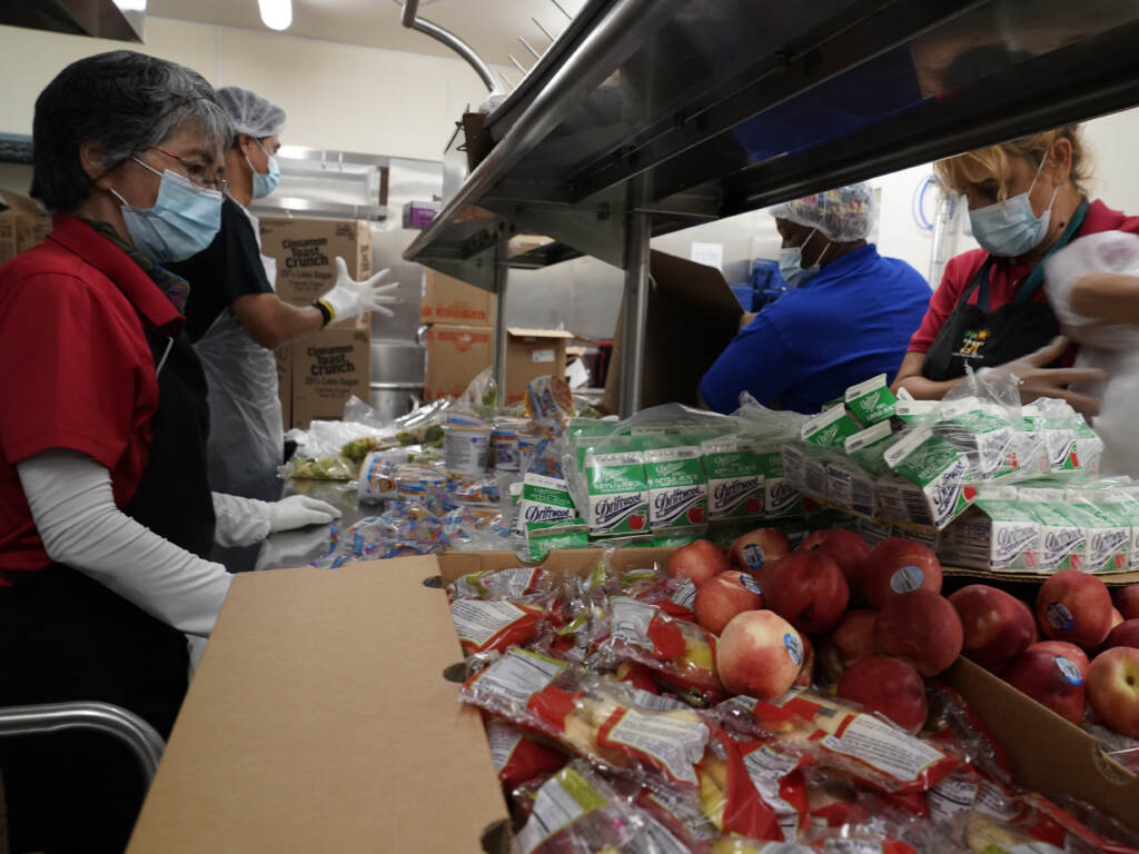 Los Angeles Unified School District food service workers pre-package hundreds of free school lunches in plastic bags. Service workers pre-package hundreds of free school lunches in plastic bags. (Damian Dovarganes/AP)