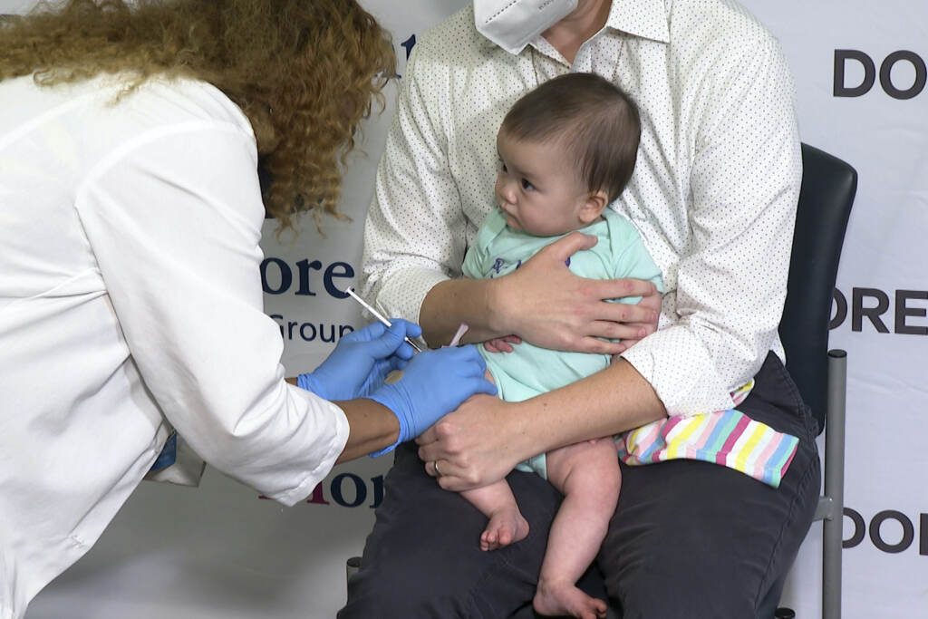 Virus Outbreak Vaccines Kids Ellen Fraint holds her daughter, 7-month-old Jojo, as she receives the first dose of the Moderna COVID-19 vaccine.