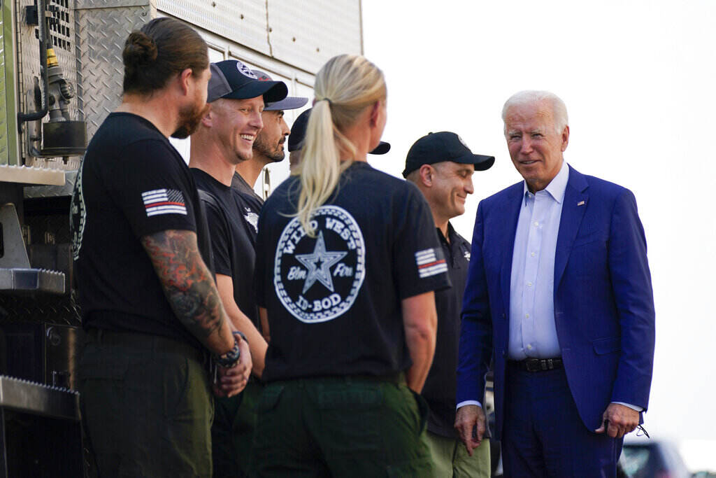 President Biden stands with a group of federal firefighters.