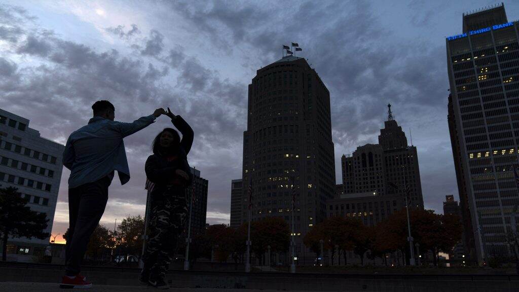 detroit-1024×576 People dance in Detroit as the sun sets behind the skyline in November 2020. (David Goldman/AP Photo)