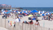 Beachgoers are seen on the beach at the Jersey Shore, with the ocean in the background.