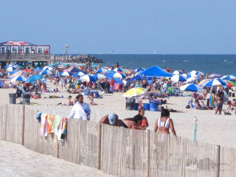 Beachgoers are seen on the beach at the Jersey Shore, with the ocean in the background.