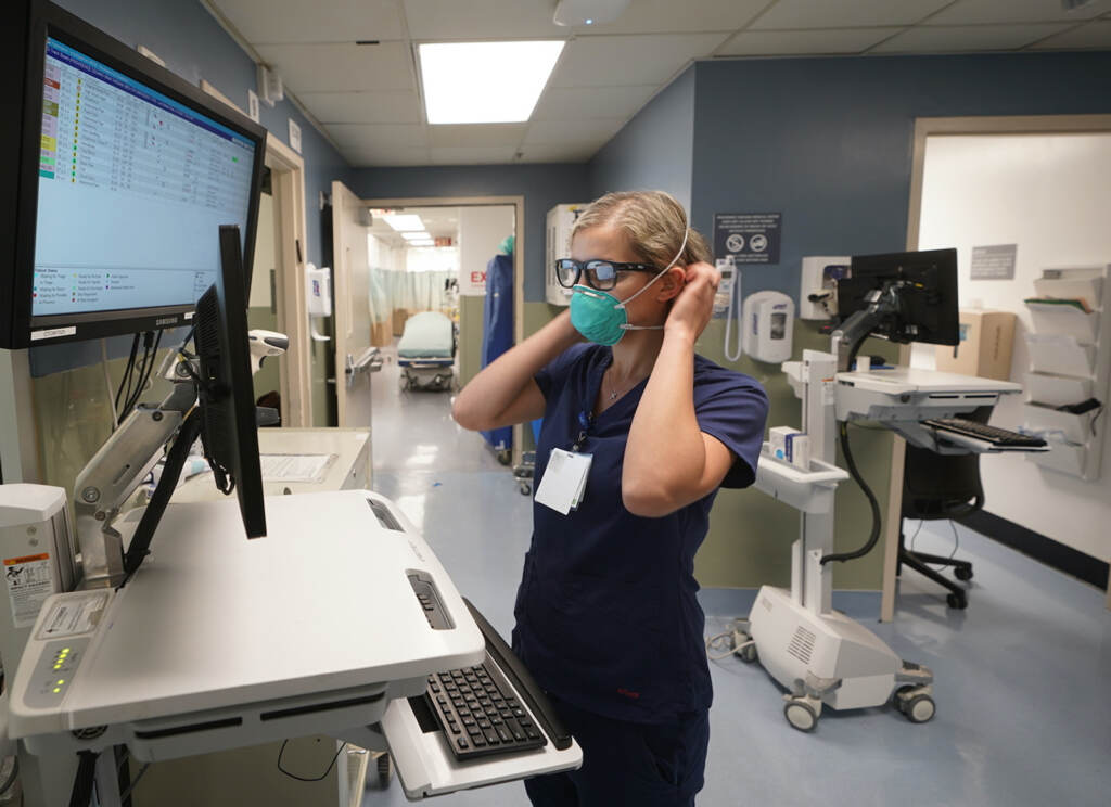 Sandra Younam Sandra Younan adjusts her N95 face mask as she checks her patients records at the emergency room