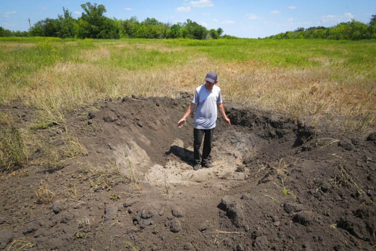 Farmer Serhiy, a local grain producer, shows a crater left by a Russian shell on his field in the village of Ptyche in eastern Donetsk region, Ukraine, Sunday, June 12, 2022. Serhiy claims he cannot sell his grains because nobody wants to come to the area which has been under Russian shelling. Ukraine is one of the world’s largest exporters of wheat and corn but Russia's invasion and a blockade of its ports have halted much of that flow.
