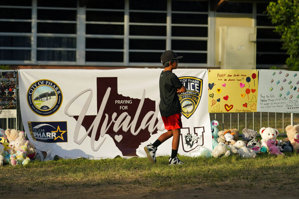 Texas School Shooting A boy walks in front of a memorial to the victims of the mass shooting in Uvalde, Texas.