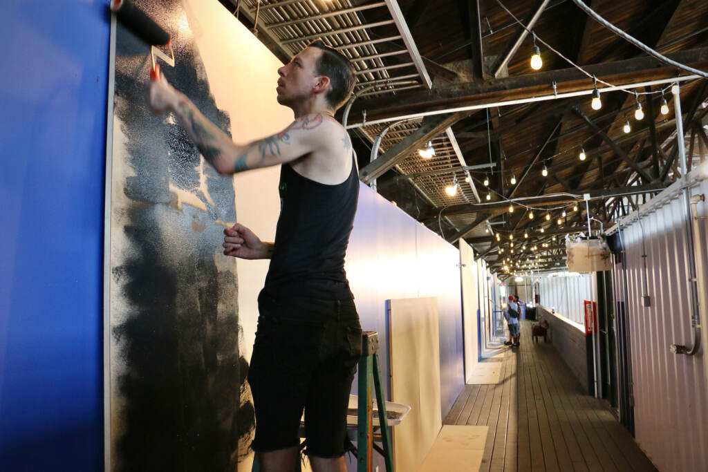 2022 07 08-e lee-sean dooley-philadelphia cherry street pier-tiny room for elephants black Sean Dooley, a first time participant in the Tiny Room for Elephants art festival, prepares his canvas at the Cherry Street Pier. (Emma Lee/WHYY)