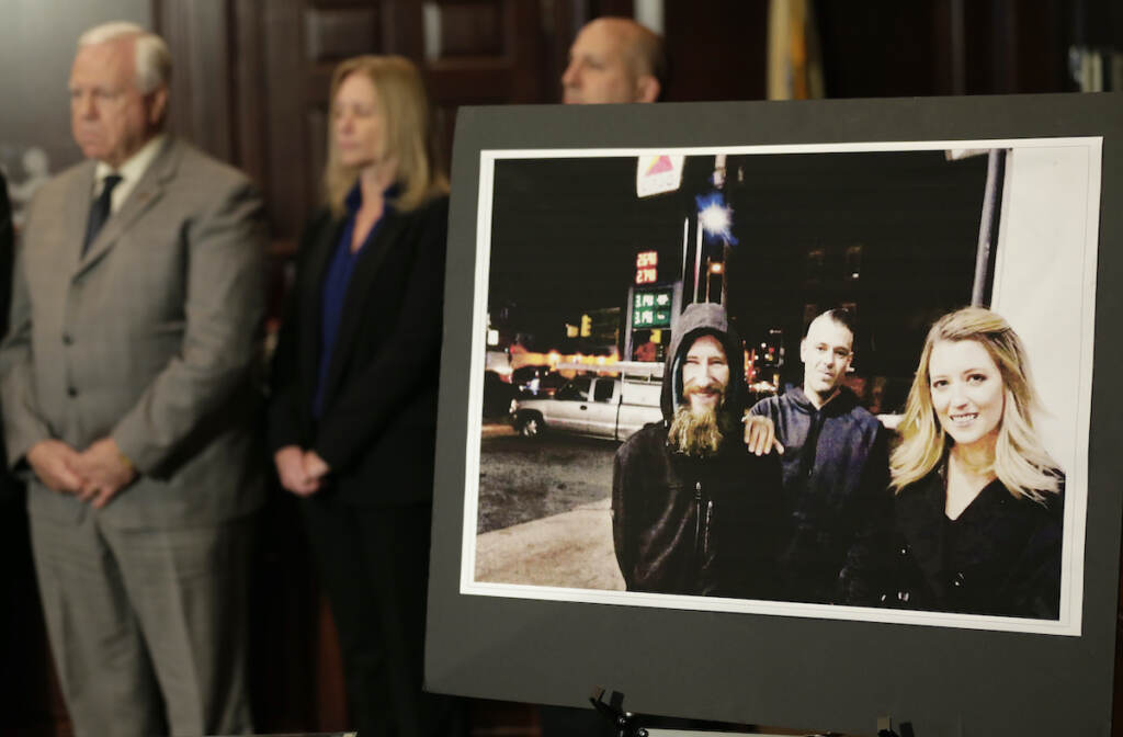 Helpful Homeless Man A photo of three people is displayed. People stand at attention behind it.