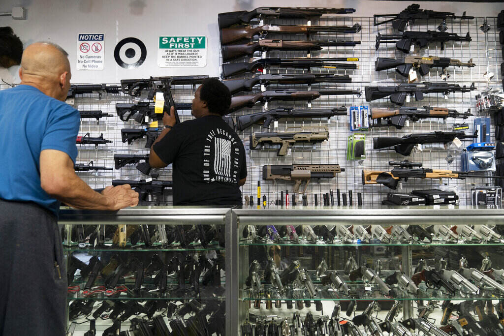 Supreme Court Guns California Sales associate Elsworth Andrews grabs a shot gun to show it to a customer at Burbank Ammo & Guns in Burbank, Calif., Thursday, June 23, 2022. The Supreme Court has ruled that Americans have a right to carry firearms in public for self-defense, a major expansion of gun rights. The court struck down a New York gun law in a ruling expected to directly impact half a dozen other populous states. (AP Photo/Jae C. Hong)