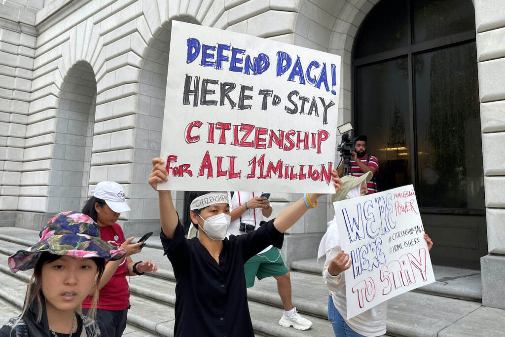 Immigration Deferred Action Demonstrators hold up signs outside the 5th U.S. Circuit Court of Appeals building in New Orleans on Wednesday, July 6, 2022. (AP Photo/Kevin McGill)