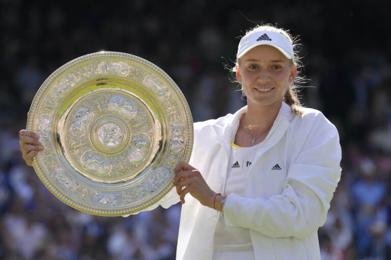 Kazakhstan's Elena Rybakina holds the trophy as she celebrates after beating Tunisia's Ons Jabeur to win the final of the women's singles on day thirteen of the Wimbledon tennis championships in London, Saturday, July 9, 2022. (AP Photo/Kirsty Wigglesworth)