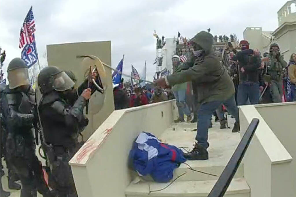 Capitol Riot Sentencing In this image from a Washington Metropolitan Police Department officer's body-worn video camera, and contained in the statement of facts supporting an arrest warrant for Mark Ponder, Ponder strikes an officer with a pole on the West Front of the U.S. Capitol on Jan. 6, 2021, in Washington. (Department of Justice via AP)