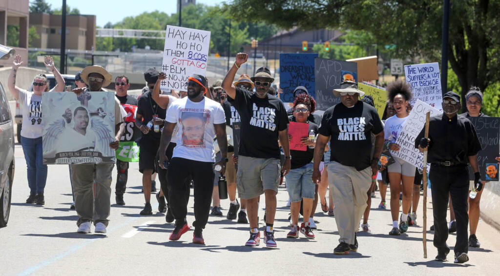 Fatal Police Shooting Ohio A group of people walks, carrying signs protesting the police shooting and death of Jayland Walker.